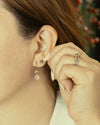 Close-up of a person wearing earrings with a blurred background