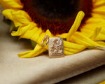 Sunflower charm on a yellow sunflower with a beige background